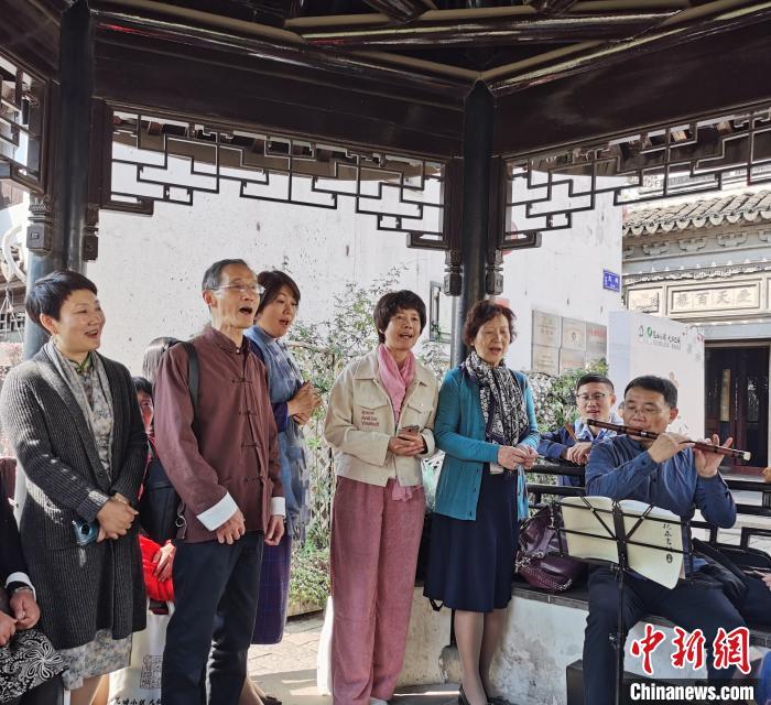 无需繁复的化妆与精致的舞台，兴之所至，曲友们就在小镇路边唱上一曲?！≈由?摄